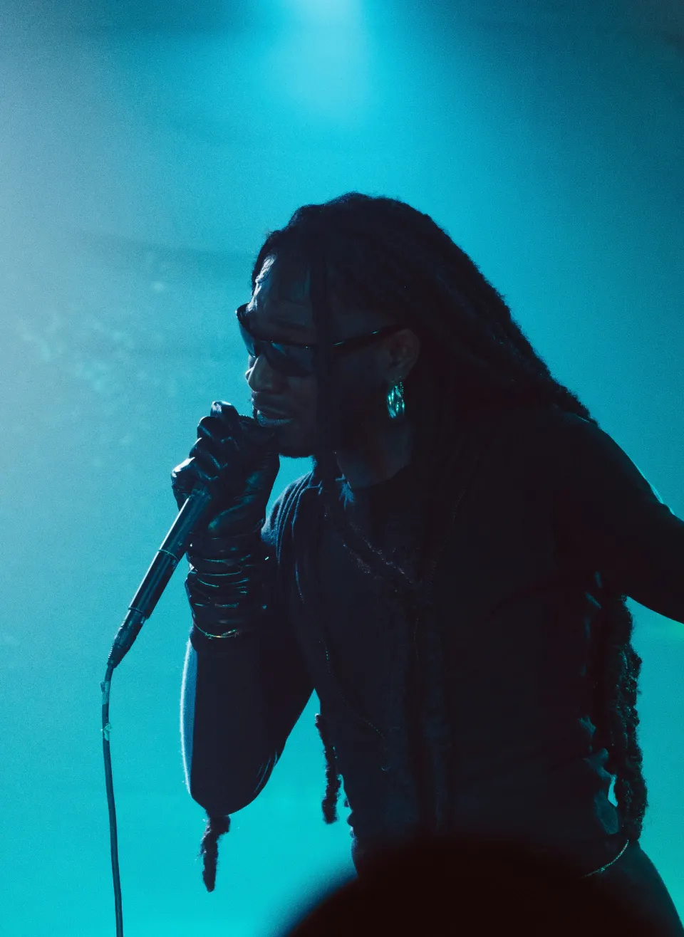 A singer performing under blue stage light