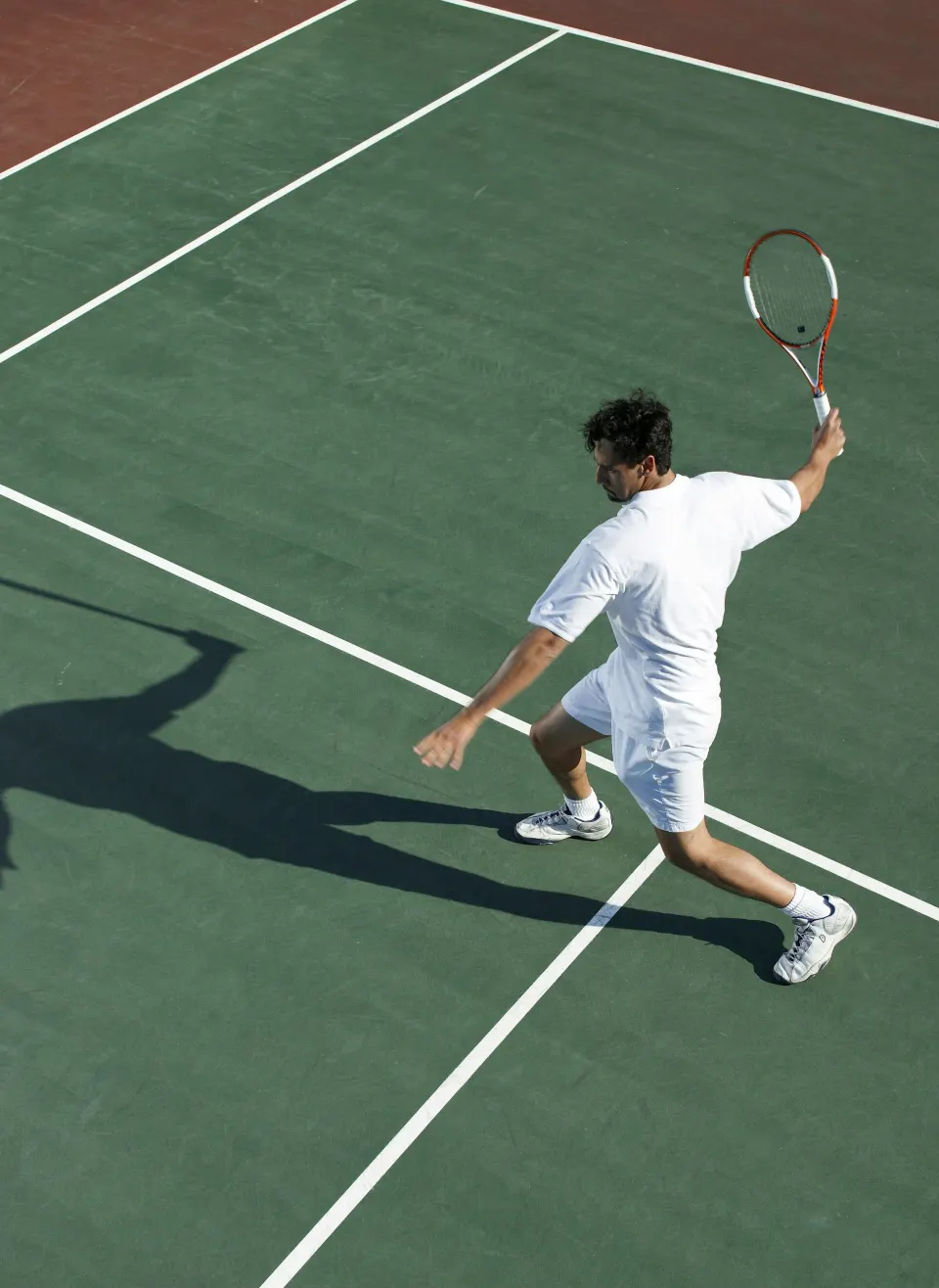 A tennis player serving on an outdoor court