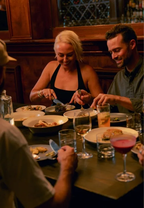 Friends sharing dinner in a warmly lit restaurant